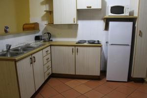a kitchen with a white refrigerator and a sink at Mogodi Lodge in Graskop