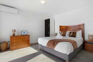 Un dormitorio con una cama grande con cabecero de madera. en Original Wave House, en Jardim do Mar
