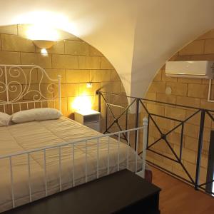 una camera da letto con un letto e un muro di mattoni di Maison Voltige a Bari