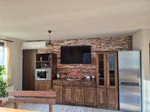a living room with a television on a brick wall at Villa Kashtata in Resilovo