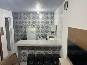 a bathroom with a sink and a counter with chairs at Kitnet Muriqui 1 in Mangaratiba +21 photos
