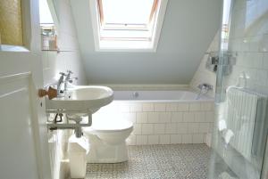 a bathroom with a sink and a toilet and a tub at DE103 - Charming farm style home on a large estate in Domburg +13 photos