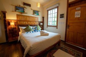 una camera da letto con un grande letto bianco in una stanza di The Corbin a Fehendhoo