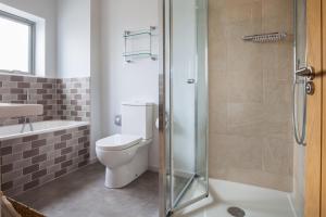a bathroom with a toilet and a glass shower at Sloopside Apartment in the centre of Bantham with sea views in Bantham +12 photos