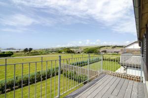 a balcony with a fence and a view of a field at Sloopside Apartment in the centre of Bantham with sea views in Bantham