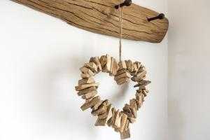 a wreath made out of wood hanging on a wall at Sloopside Apartment in the centre of Bantham with sea views in Bantham
