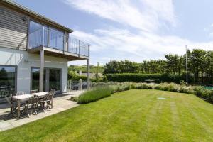 a patio with a table and chairs in a yard at Sloopside Apartment in the centre of Bantham with sea views in Bantham