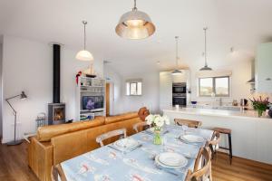 a living room with a table and a couch at Sloopside Apartment in the centre of Bantham with sea views in Bantham