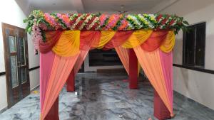 a stage with colorful curtains and flowers on it at Aashirwad Residency Inn in Gaya