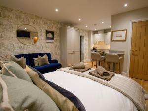 a bedroom with a large bed and a blue couch at Hardriggs Bank Cottage in Kendal