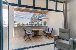a balcony with a table and chairs and a window at RentitSpain Castell Playa, vistas y parking in Castell de Ferro