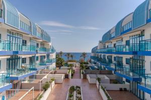 an apartment building with balconies and the ocean in the background at RentitSpain Castell Playa, vistas y parking in Castell de Ferro