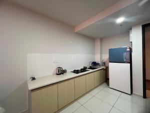a kitchen with a refrigerator and a counter top at La Dimora Guesthouse in Rawang