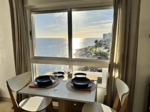 una mesa con vistas al océano desde una ventana en Beachfront Studio ,The View Calahonda, Panoramic Sea Views, en Mijas Costa