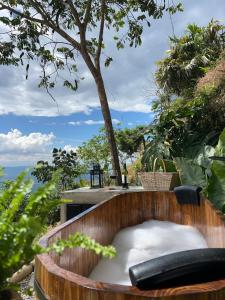 a wooden tub filled with snow next to a tree at Cabaña el Refugio Buenavista in Buenavista