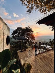 a deck with an umbrella and a table and chairs at Cabaña el Refugio Buenavista in Buenavista