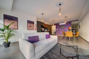 a living room with a couch and a table at Kuya Suites by Haven and Keys Malta in Is-Swieqi