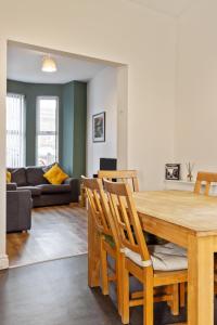 a dining room and living room with a wooden table and chairs at Clondara Terrace Belfast in Belfast