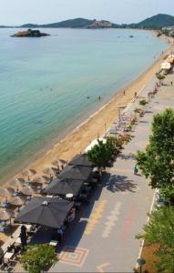 una playa con muchas sombrillas y el océano en Dimi apartment, en Nea Peramos