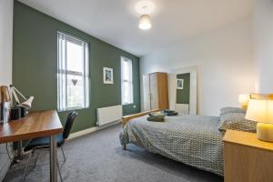 a bedroom with a bed and a desk and a desk at Clondara Terrace Belfast in Belfast