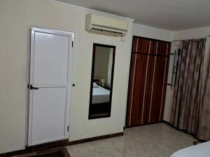 a room with a mirror and a bedroom with a bed at Emam apartments in Grand-Baie