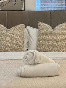 toalla blanca sobre una cama con almohadas en Spacious 2 Bed, 2 Bath Apartment by MCF, en Horley