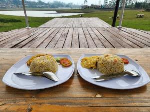 two plates of food on a wooden table at Seribu Pulau Pangalengan in Citere