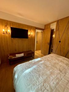 a bedroom with a large bed and a flat screen tv at Appartamento nuovo Sankt Moritz Chesa arlas 3B in St. Moritz