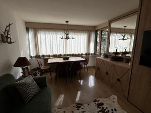 a living room with a table and a dining room at Appartamento nuovo Sankt Moritz Chesa arlas 3B in St. Moritz