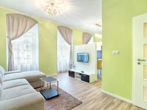 ein Wohnzimmer mit einem Sofa und einem TV in der Unterkunft Apartment Ondrejska 20 in Karlsbad