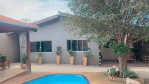 une maison avec des plantes en pot et une piscine dans l'établissement Cantinho do Sossego, à Olímpia