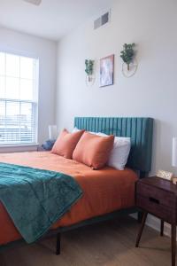 a bedroom with a bed with orange sheets and pillows at 2 Story Penthouse 2 Balconies, Skyline View, Pool in Richmond +44 photos