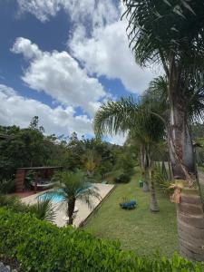 ein Resort mit Swimmingpool und Palmen in der Unterkunft Casa de Campo no Oliveira in Tijucas