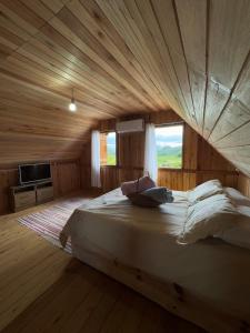 ein großes Bett in einem Zimmer mit Holzdecke in der Unterkunft Casa de Campo no Oliveira in Tijucas + 48 Fotos