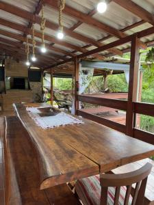 einen großen Holztisch im Wohnzimmer mit einem Tisch in der Unterkunft Casa de Campo no Oliveira in Tijucas