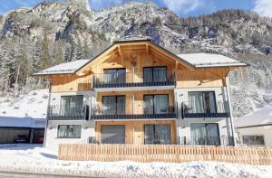 a large wooden building with a mountain in the background at Alpenresidenz Hotel Gell in Tweng