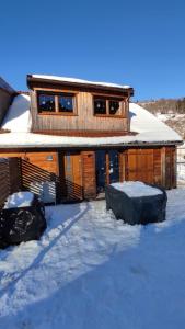 Una cabaña de troncos en la nieve con dos cúpulas en Valley Lodge, en La Bresse