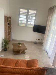 a living room with a couch and a table at Villa Sarique in Grand-Bourg