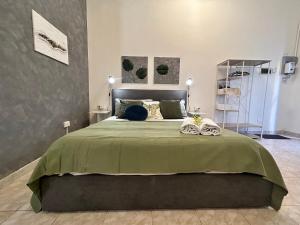 une chambre avec un grand lit avec une couverture verte dans l'établissement Cuddly Apt, comodo per coppie e parcheggio, à Mestre
