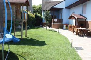 a yard with a playground and a table and a building at Gästehaus Schneider in Illmitz +6 photos