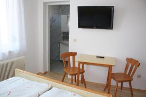 a room with a table and two chairs and a television at Gästehaus Schneider in Illmitz