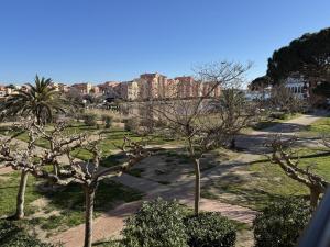 a park with trees and buildings in the background at Barcazen in Le Barcarès