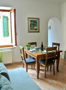 Un comedor con mesa y sillas de madera. en casamolino57, en Molino del Piano