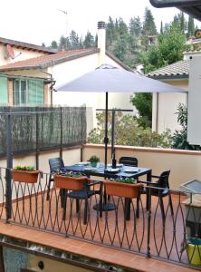 un patio con una mesa y una sombrilla en casamolino57, en Molino del Piano