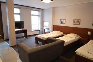 Una habitación de hotel con dos camas, un sofá y un televisor. en Apartamenty Centrum Konopnicka Stargard, en Stargard