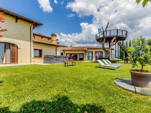 a yard with two chairs and a balcony on a house at Villa La Stella di Gioia in Cantalupo in Sabina
