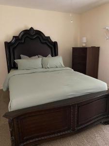 a large bed in a bedroom with a wooden headboard at The Ultimate Staycation in San Antonio +45 photos