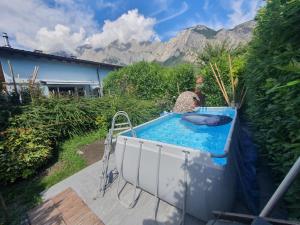 a hot tub in a yard with mountains in the background at Magnifique VILLA de 120m2 au Coeur du Valais avec piscine en été in Chamoson