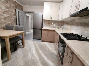 a kitchen with a table and a stove top oven at Apartament lux new in Chişinău