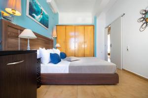 a bedroom with a large bed with blue walls at Irini Apartment I in Kalyves